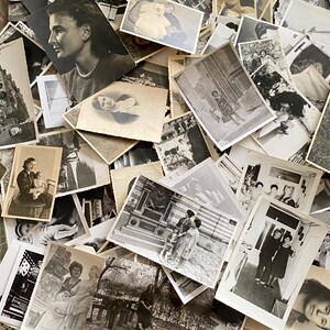 May include: A large pile of black and white photographs, some with people, some with landscapes, and some with objects. The photographs are arranged in a random order and are all different sizes.