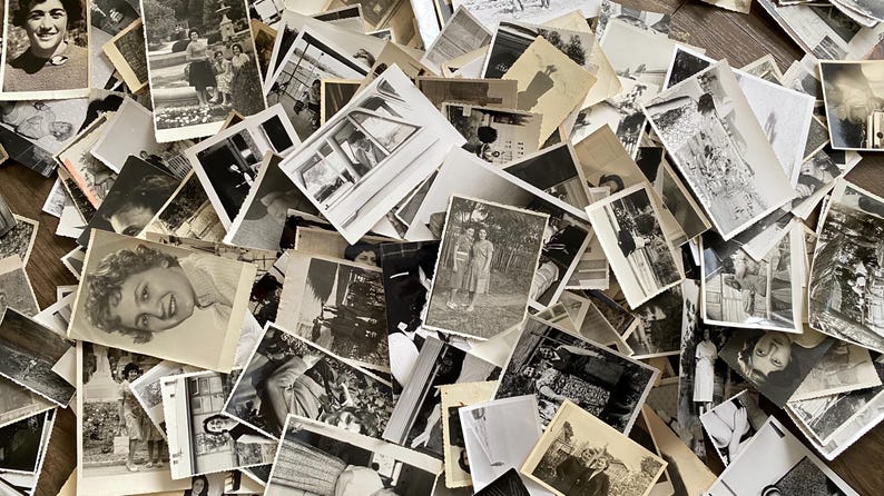 May include: A large pile of black and white photographs, some with people in them, others with landscapes or buildings. The photos are all different sizes and shapes, and they are arranged in a random order.