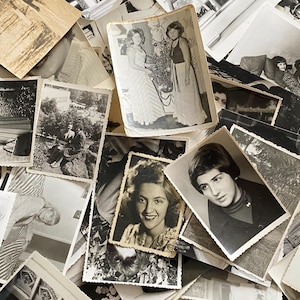 May include: A pile of black and white photographs, some with people in them, others with landscapes or objects. The photos are arranged in a random order, creating a chaotic and nostalgic feel.