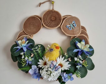 Wreath made of handcrafted wooden logs decorated with blue and white eucalyptus flowers a chick rabbits a butterfly "PETIT POUSSIN BLEU"