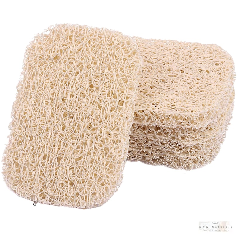 May include: A stack of beige, rectangular loofah sponges. The sponges have a woven, open texture. One sponge is separated from the stack, showing its shape. The loofahs are a natural color and appear to be made from plant fibers. The image is well-lit.