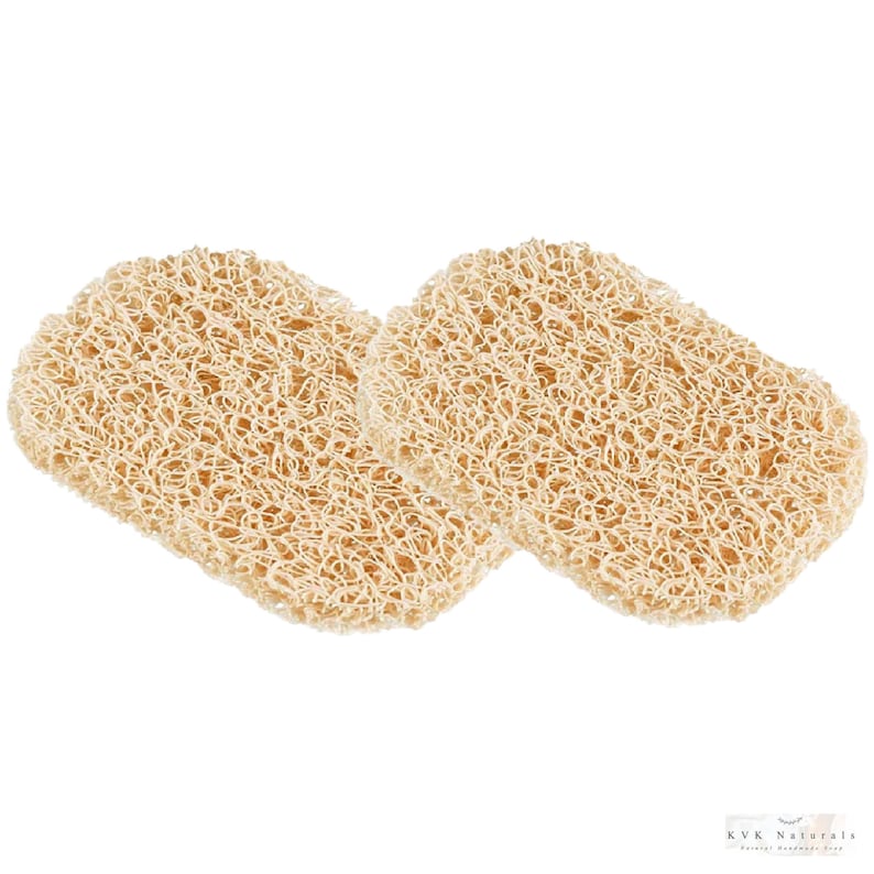 May include: Two beige, rectangular bath sponges with a textured, woven appearance. The sponges are made of a natural material and are designed for use in the bath or shower. The image is set against a white background.