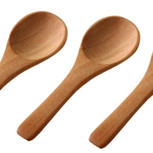May include: Three wooden spoons with oval bowls and long handles are displayed against a white backdrop. The spoons are made of light-coloured wood and appear unused. The spoons are likely for cooking or serving, each measuring approximately 15 cm in length.