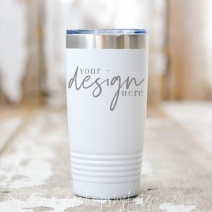 May include: White insulated tumbler with a silver rim and lid. The text "your design here" is printed on the front in gray script. The tumbler has horizontal grooves near the bottom and is set against a rustic wooden background.