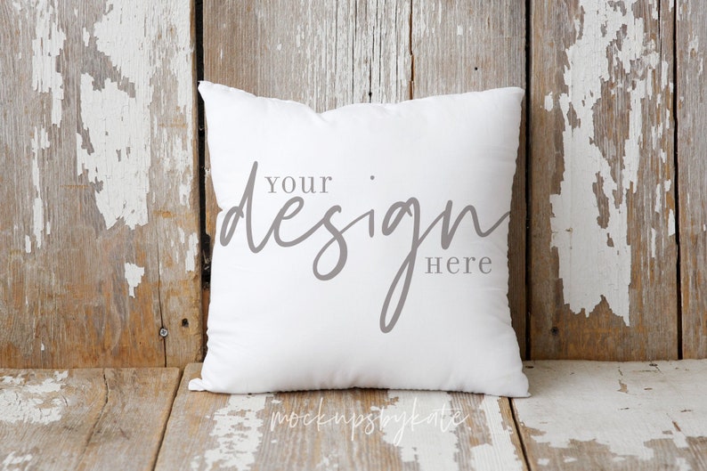 Puede incluir: Almohada blanca con el texto "Your design here" sobre un fondo de madera r&uacute;stico.