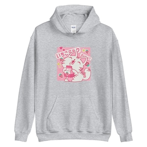K&ouml;nnte beinhalten: Hellgrauer Kapuzenpullover mit einem rosa quadratischen Aufdruck, der eine Comic-Katze beim Trinken von Erdbeermilch zeigt. Der Aufdruck enth&auml;lt japanischen Text, Erdbeeren und Sterne. Der Kapuzenpullover hat eine Kapuze und eine Vordertasche.
