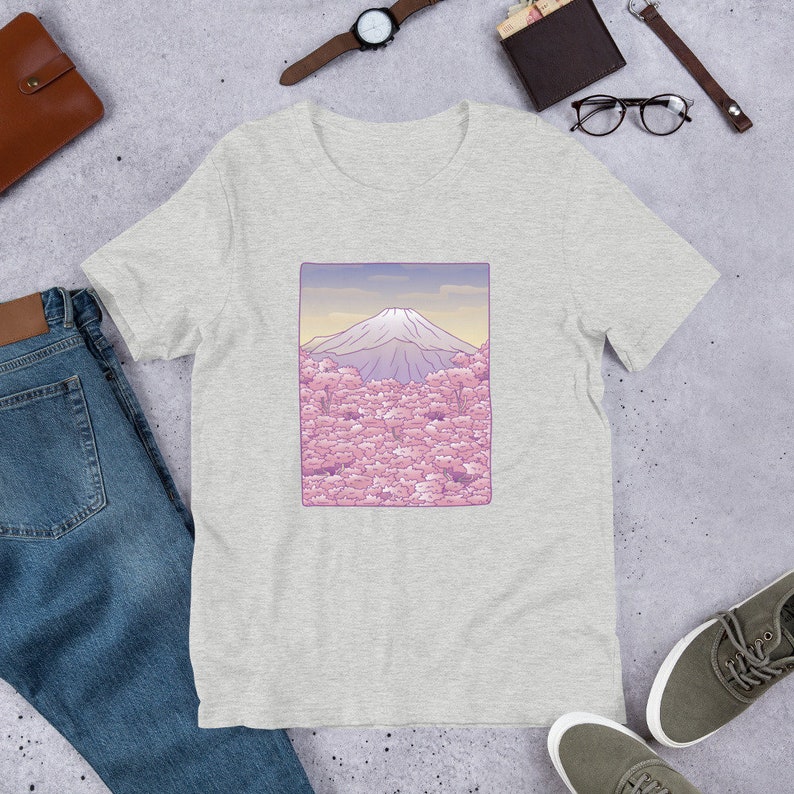 Puede incluir: Una camiseta gris con un gr&aacute;fico de Mount Fuji y flores de cerezo rosas.