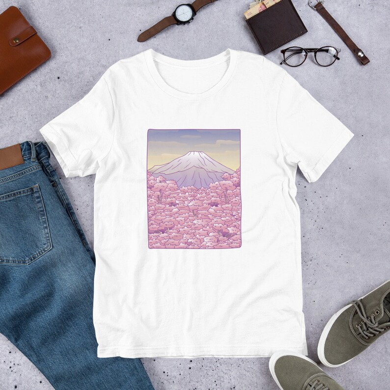 Puede incluir: Camiseta blanca con un gr&aacute;fico de Mount Fuji y flores de cerezo rosas.