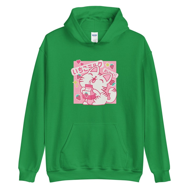 K&ouml;nnte beinhalten: Gr&uuml;ner Kapuzenpullover mit einem Aufdruck einer wei&szlig;en Katze, die Erdbeermilch trinkt. Die Grafik enth&auml;lt japanischen Text und rosa Erdbeerakzente. Der Pullover hat eine Vordertasche und eine Kapuze mit Kordelzug.