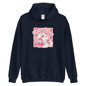 K&ouml;nnte beinhalten: Marineblauer Kapuzenpullover mit einer Cartoon-Katze, die Erdbeermilch trinkt. Die Grafik enth&auml;lt japanischen Text und Erdbeerillustrationen auf rosa Hintergrund. Der Hoodie hat eine Kapuze mit Kordelzug und eine K&auml;ngurutasche.