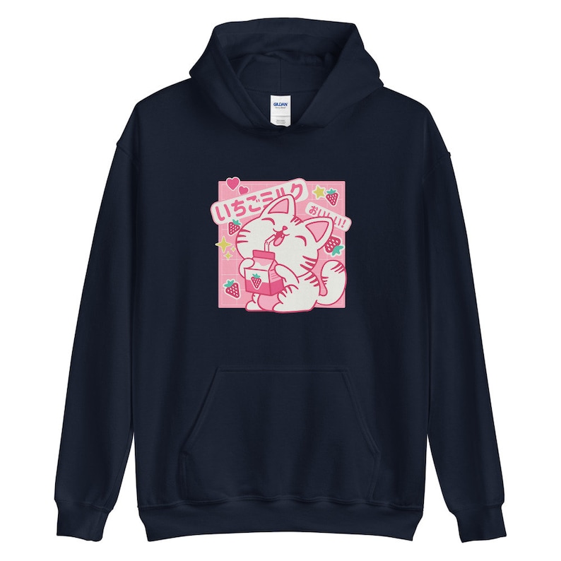 K&ouml;nnte beinhalten: Marineblauer Kapuzenpullover mit einer Cartoon-Katze, die Erdbeermilch trinkt. Die Grafik enth&auml;lt japanischen Text und Erdbeerillustrationen auf rosa Hintergrund. Der Hoodie hat eine Kapuze mit Kordelzug und eine K&auml;ngurutasche.