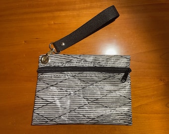 Recycled laminate sailcloth wristlet - 8 1/2”W x 6”H - zipper - lined - black webbing strap handle - opaque laminate w/ black kevlar fibers