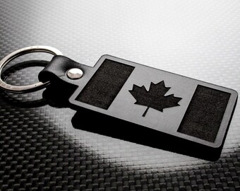May include: Black leather keychain with a silver key ring and a black leather tag featuring a cutout of the Canadian flag.