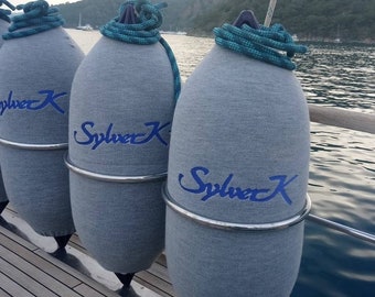 May include: Three gray cylindrical boat fenders with a silver metal band around the middle. Each fender has the text "Sylver K" embroidered in blue.