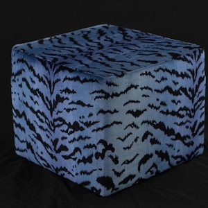 May include: A blue and black cube-shaped ottoman with a tiger stripe pattern.