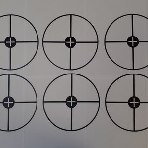 Könnte beinhalten: Sechs schwarze und weiße Zielkreise mit einem Fadenkreuz in der Mitte. Die Ziele sind auf ein weißes Blatt Papier gedruckt.