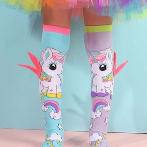 以下が含まれることがあります： ユニコーン、虹、雲のデザインのニーハイソックスのペア。ソックスは青と紫で、ピンクと黄色のアクセントが付けられています。