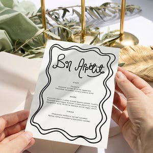 Może przedstawiać: Biała karta menu z czarną falistą ramką. Tekst "Bon Appetit" jest napisany czarnym, ozdobnym pismem. Menu zawiera następujące pozycje: Start, Udostępnij, Zakończ. Pozycje menu są napisane czarną czcionką.