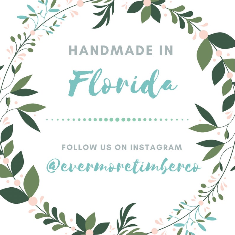 Może przedstawiać: Białe tło z zielonym i niebieskim wieńcem kwiatowym. W środku wieńca znajduje się tekst "HANDMADE IN Florida". Pod tekstem znajduje się przerywana linia i tekst "FOLLOW US ON INSTAGRAM @evermoretimberco".
