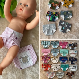 Könnte beinhalten: Eine Sammlung bunter und gemusterter Babywindeln, darunter eine Windel mit einem Schafmotiv. Die Windeln sind aus weichem, atmungsaktivem Stoff gefertigt und perfekt, um Ihr Kleines trocken und bequem zu halten.