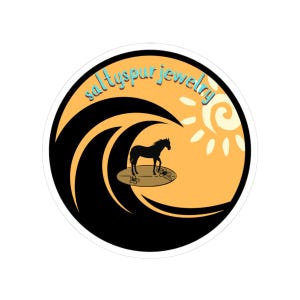 May include: Round sticker featuring a black horse surfing on a surfboard, set against a yellow and orange backdrop. The design includes a stylized sun and a large black wave. The text "saltyspur jewelry" is written in light blue, curved across the top.
