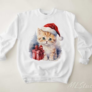 May include: White sweatshirt featuring a watercolour illustration of a kitten wearing a Santa hat and holding a red gift box.
