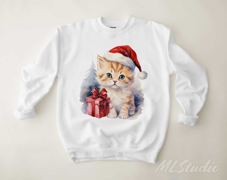 May include: White sweatshirt featuring a watercolour illustration of a kitten wearing a Santa hat and holding a red gift box.