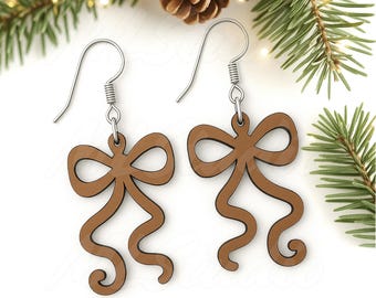 May include: A pair of brown bow-shaped earrings with silver hooks. The earrings are made of wood and have a detailed design. The image also includes text that reads "SVG - EPS - PNG".