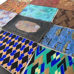 May include: A collection of patterned paper samples, including geometric designs, abstract patterns, and a sample with the text "Fancy Range 1938".
