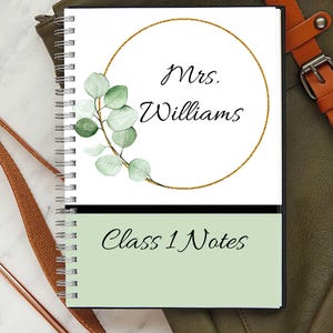 May include: Spiral-bound notebook with a white cover featuring a gold circle, eucalyptus leaves, and the name "Mrs. Williams." The bottom section is light green with the text "Class 1 Notes."