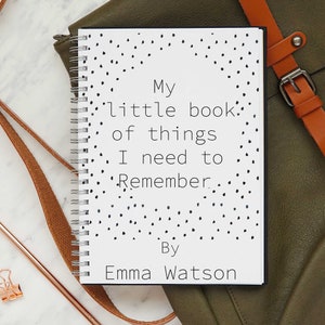 May include: A white notebook with black polka dots and the text "My little book of things I need to remember. By Emma Watson" on the cover.