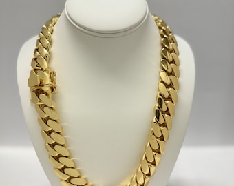 May include: A gold chain necklace with a curb link design. The chain is thick and has a shiny finish.