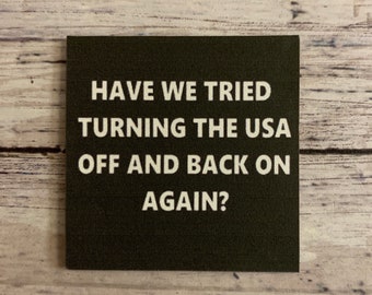 Puede incluir: Un letrero cuadrado verde oscuro con texto blanco que dice "Have we tried turning the USA off and back on again?"