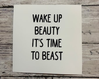 May include: White card with black text that reads "Wake up beauty it's time to beast".