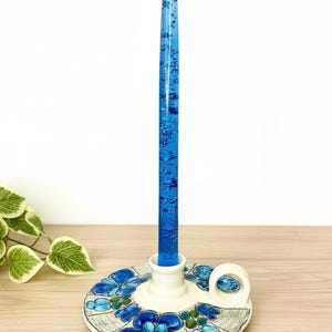 May include: A white ceramic mug with a black handle and the text "But First, Coffee" in a black, bold font. The mug is sitting on a white surface. The mug is approximately 4 inches tall.