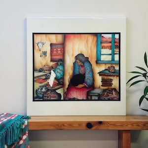 May include: A framed print depicting a Native American scene. The artwork features two figures in traditional clothing, surrounded by pottery, rugs, and a window overlooking a desert landscape. The color palette includes warm earth tones and vibrant blues.