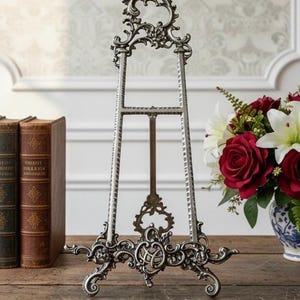 May include: A white ceramic mug with a black handle and the text "But First, Coffee" in a bold, black font. The mug is sitting on a wooden surface. The mug is approximately 4 inches tall.