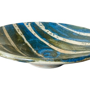 K&ouml;nnte beinhalten: Eine Keramik-Servierplatte mit einem wellenf&ouml;rmigen, blau-gr&uuml;n-wei&szlig; gestreiften Design. Die Platte ist leicht gew&ouml;lbt und hat eine gl&auml;nzende Oberfl&auml;che.