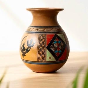 May include: A brown ceramic vase with a wide base and a narrow neck. The vase features geometric patterns in black, red, blue, and green. A black lizard-like figure is painted on the side. The vase is likely handmade.