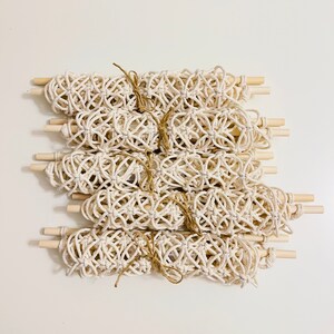 May include: A set of 10 macrame wall hangings with wooden dowels. Each hanging is made with natural cream-colored cord and tied in a knot pattern.