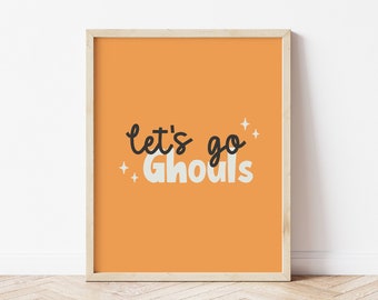 以下が含まれることがあります： オレンジ色の背景に「Let's go Ghouls」という文字が黒と白で書かれた額装されたプリント。小さな白い星が散りばめられている。