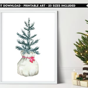 May include: Watercolor print of a Christmas tree in a white sack tied with a red bow. The tree is a muted green color, and the sack is a light gray. The print is in a white frame. Text at the top reads "INSTANT DOWNLOAD - PRINTABLE ART - 20 SIZES INCLUDED."