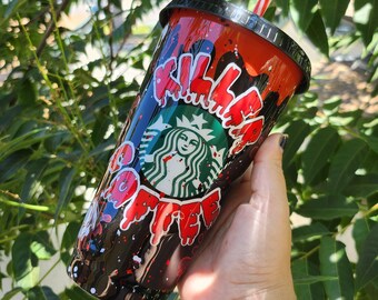 May include: A custom Starbucks tumbler with a black lid and a red and black design. The tumbler features the Starbucks logo and the words "KILL ME MATE" in red dripping letters. A red and white striped straw is inserted into the lid.