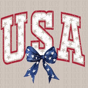 May include: A patriotic design featuring the word "USA" in bold, distressed lettering with a red outline and filled with stars. A blue bow with white stars is centered below the text, set against a neutral background.