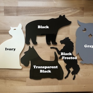 May include: Assortment of animal-shaped cutouts in various colors. Includes an ivory cat, a black bear, a gray owl, a black frosted horse, and a transparent black dog. Each cutout has the color name printed on it.