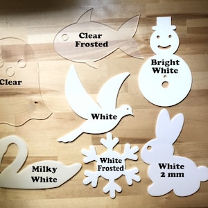 May include: A collection of laser-cut acrylic shapes in various colors and finishes. Includes a clear ghost, a clear frosted fish, a white dove, a bright white snowman, a milky white swan, a white frosted snowflake, and a white 2 mm rabbit.