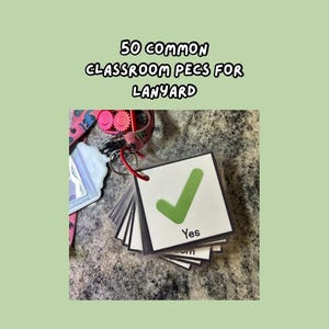 May include: A stack of small, square cards with a green checkmark and the word "Yes" printed on them. The cards are attached to a red lanyard. The text "50 Common Classroom PECS for Lanyard" is at the top.