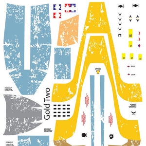 May include: A set of printable decals for a model spaceship. The decals are in various colors, including yellow, blue, gray, and red. The decals feature the text "Gold Two" and various warning signs.