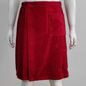 May include: A red terry cloth wrap skirt with a single pocket on the right side.