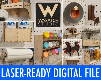 May include: Laser cut wood pegboard wall organizer with shelves, a paint can holder, a paper towel holder, and a variety of other storage solutions. The pegboard is white with black dots. The wood is a light brown color. The text "WASATCH STUDIO" is visible on a black background.